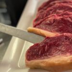 Corte de carne cruda preparado en cocina sobre bandeja antes de su cocción.