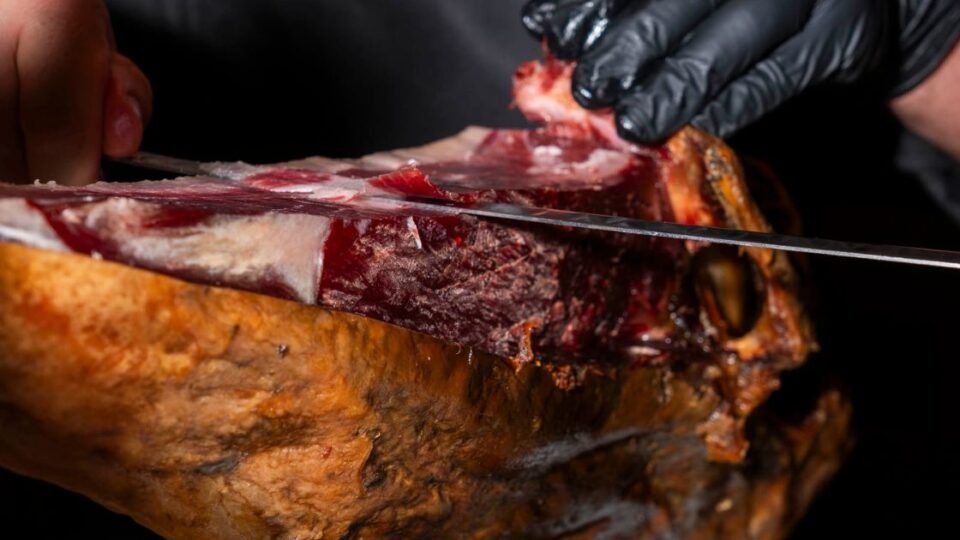 Corte de jamón ibérico a cuchillo realizado por profesional dentro del restaurante El Poncho