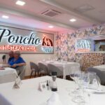 Personas adultas sentadas en las mesas del restaurante El Poncho en Playa del Inglés